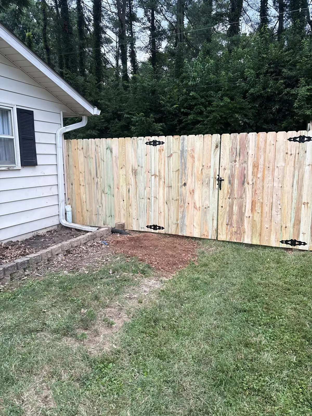 After: new wood privacy fence and gate with black hardware in the cleared side yard in Bloomington, IN