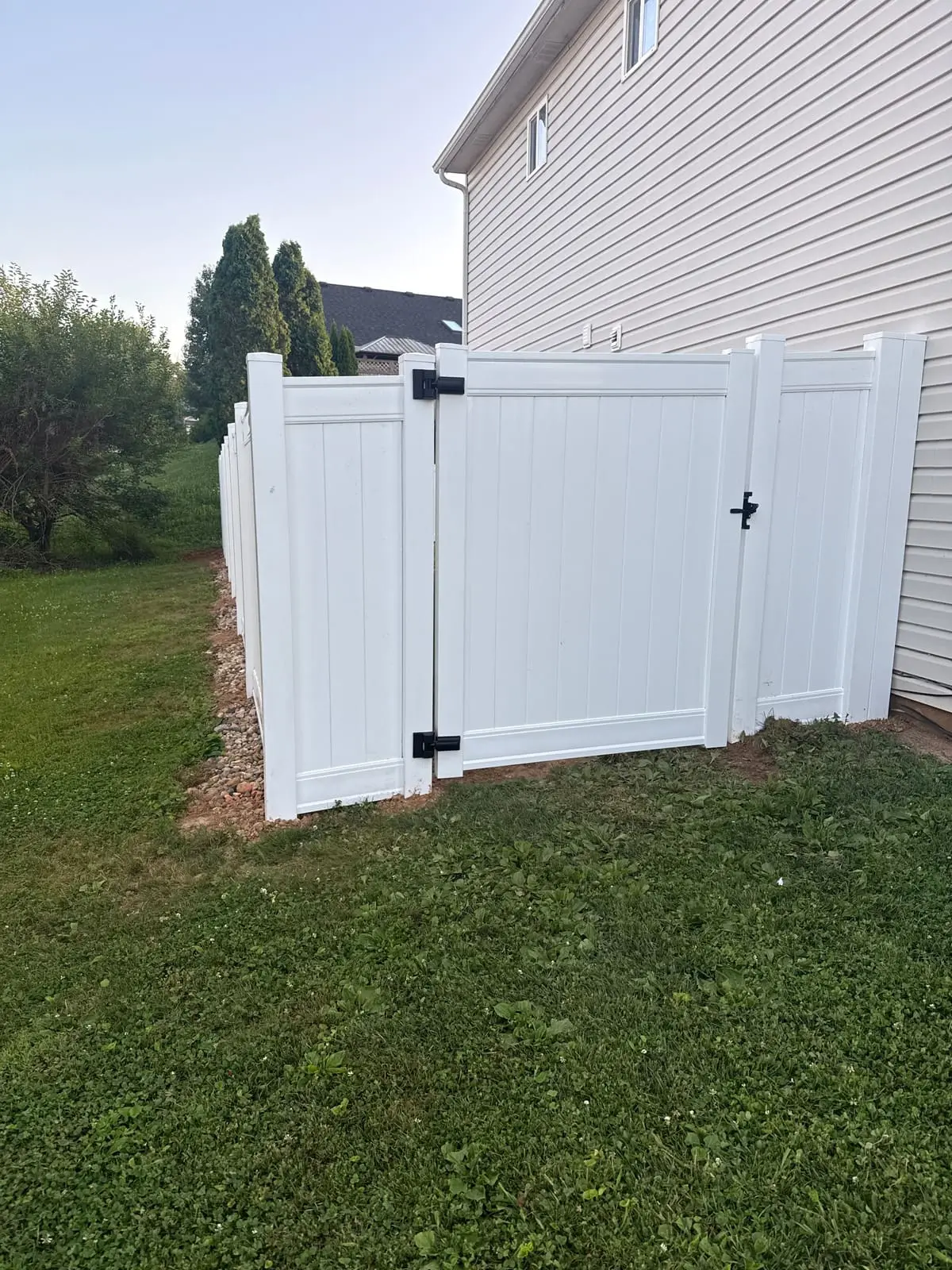 After: new white vinyl privacy fence and gate in the same corner in Bloomington, IN