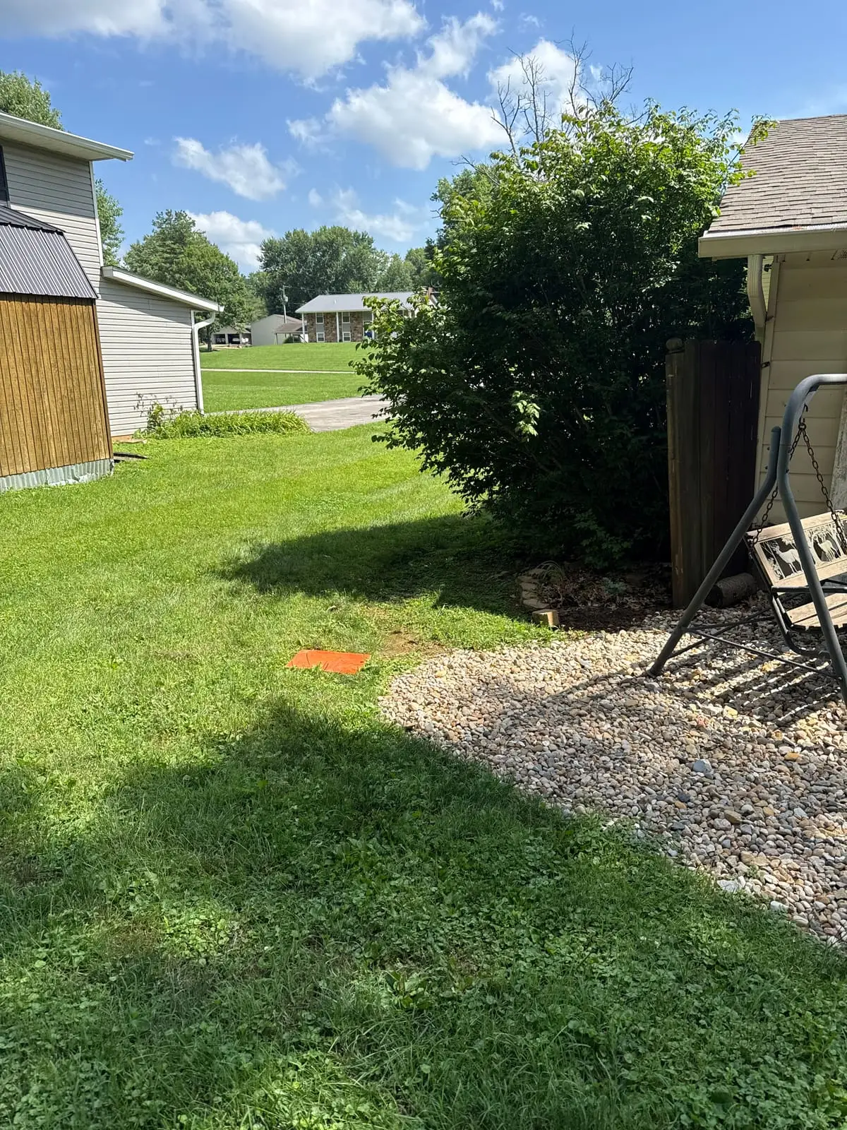 Before: open backyard with a gravel bed and no privacy from neighboring homes in Bloomington, IN