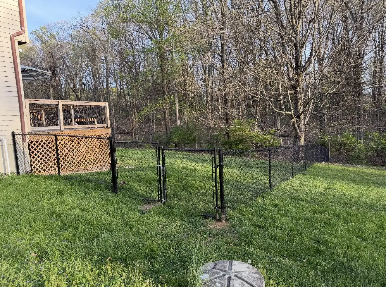 Black chain link fence installation along a backyard in Bloomington, IN