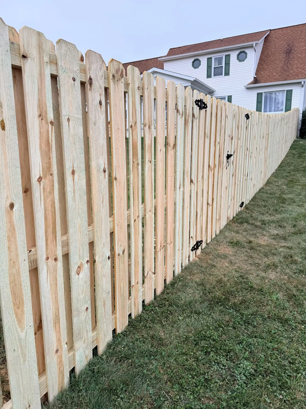 Shadowbox wood fence with gate at a two-story home in Bloomington, IN