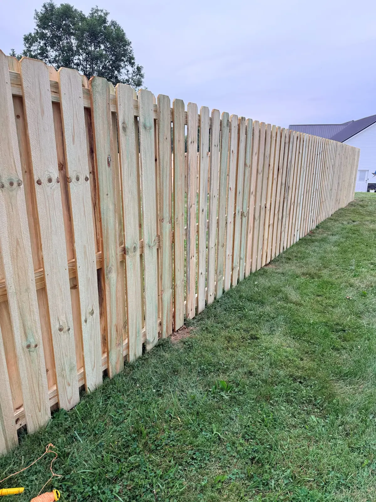 New shadowbox wood fence installation along a residential yard in Bloomington, IN
