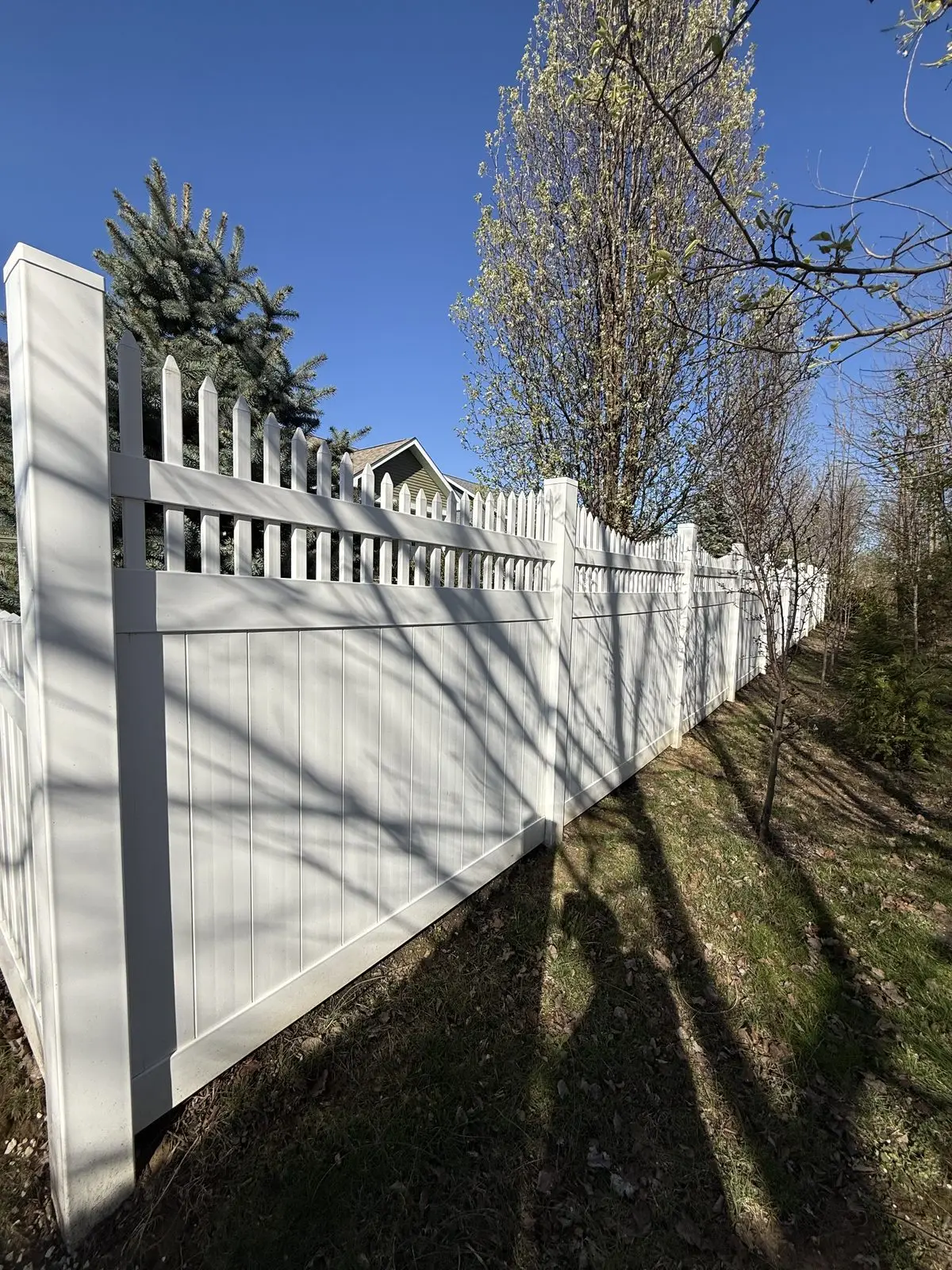 White vinyl privacy fence with a scalloped picket top in Bloomington, IN
