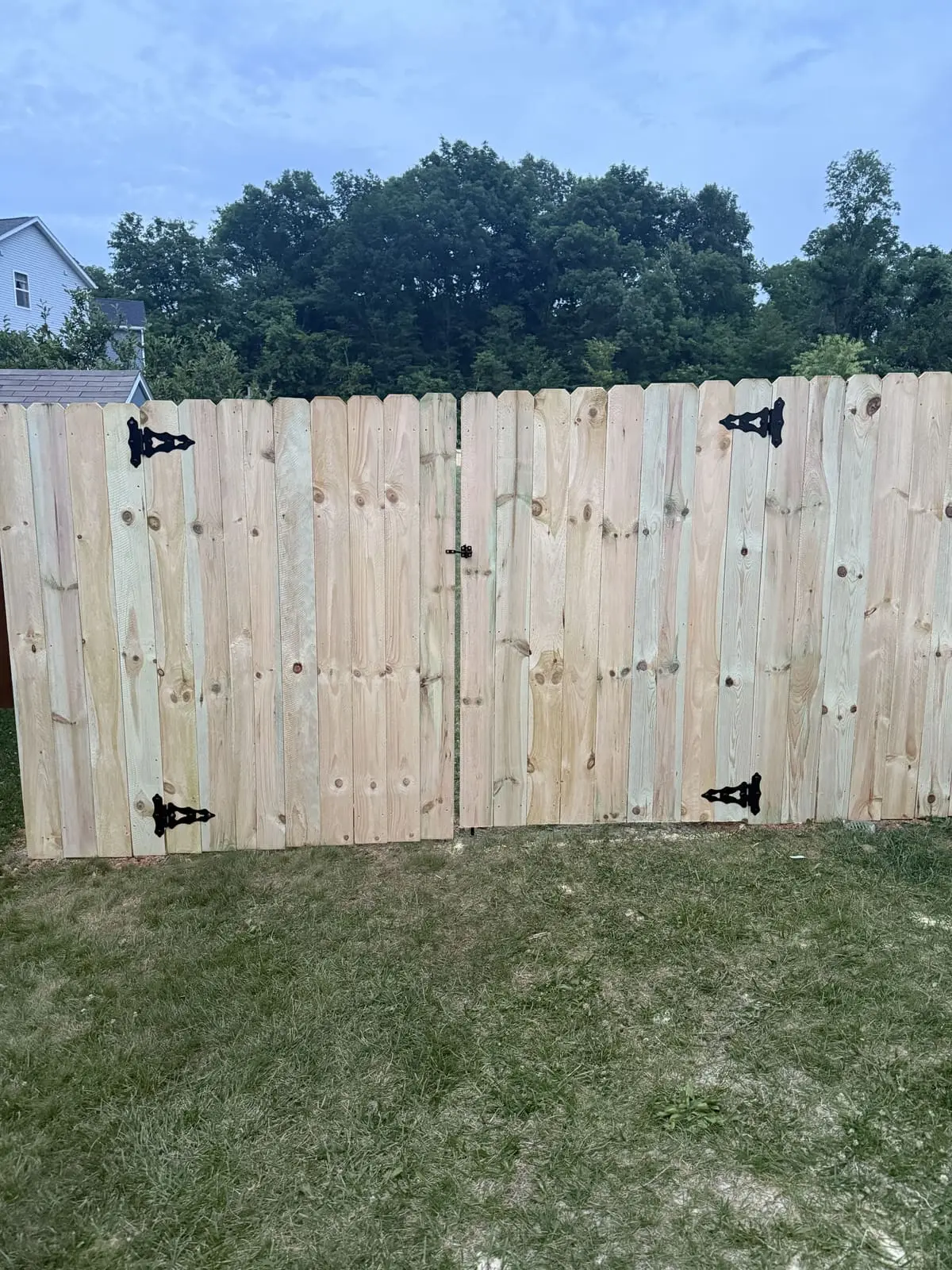 Wood fence double gate with black hinges in Bloomington, IN