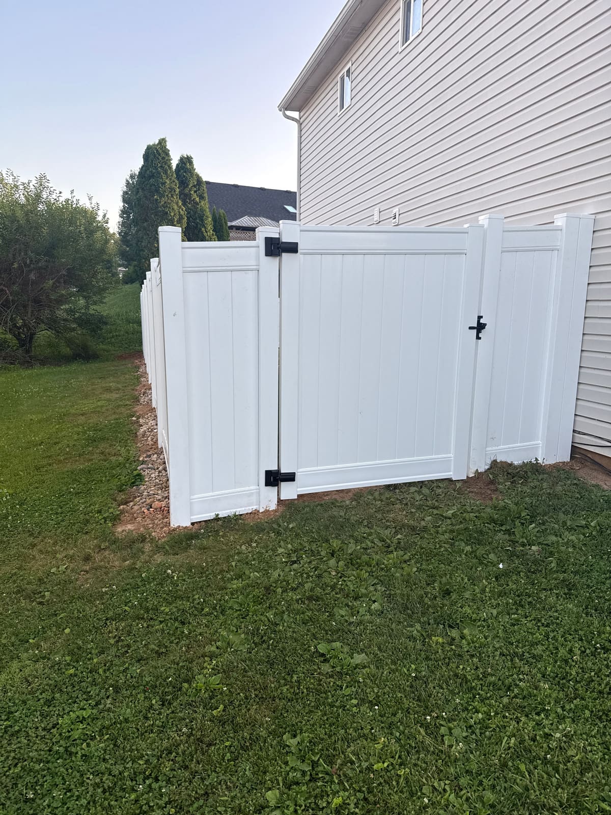 After: new white vinyl privacy fence and gate in the same corner in Bloomington, IN