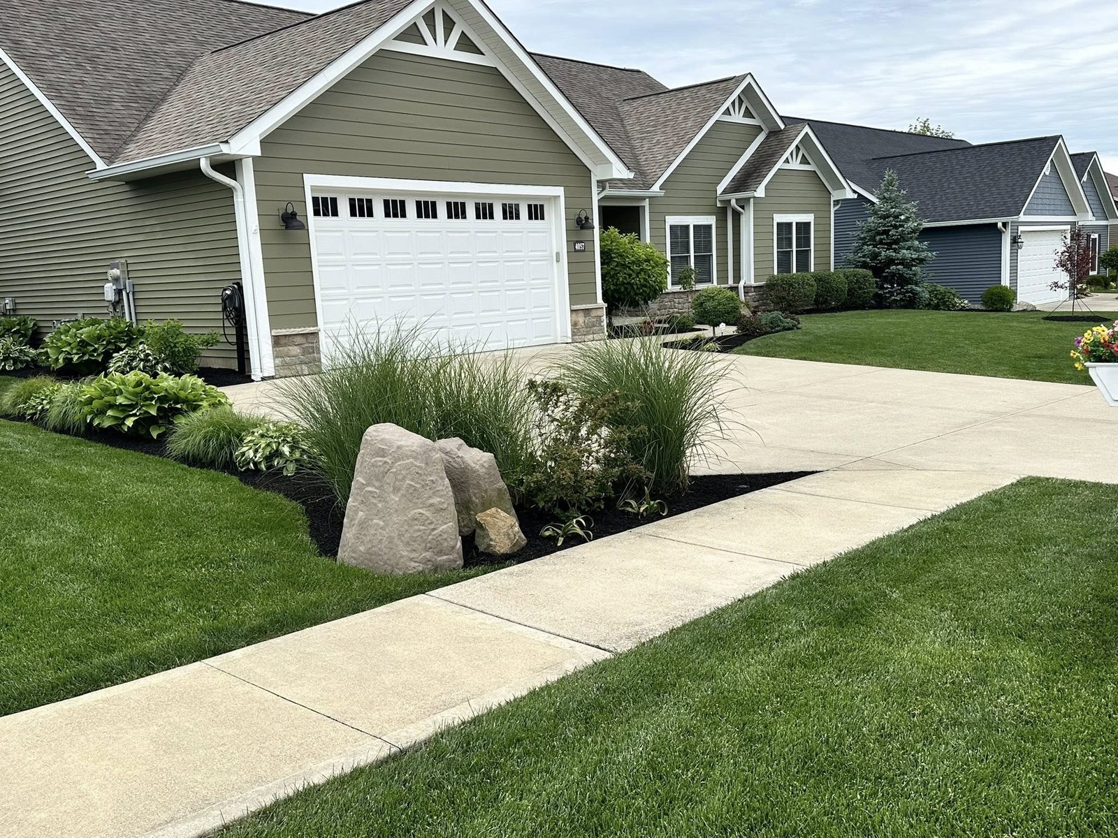 Front yard landscaping with boulders and ornamental grasses in Bloomington, IN