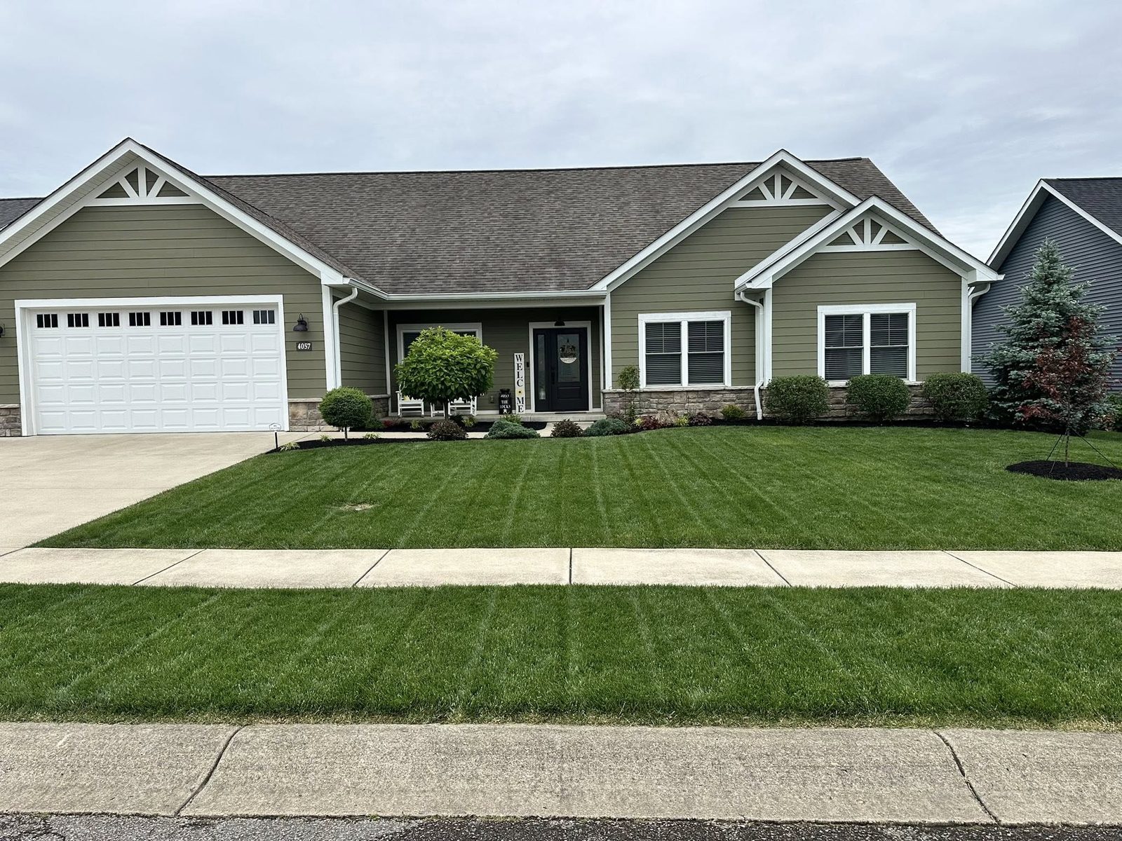 Fresh landscaping and lawn care at a craftsman ranch home in Bloomington, IN