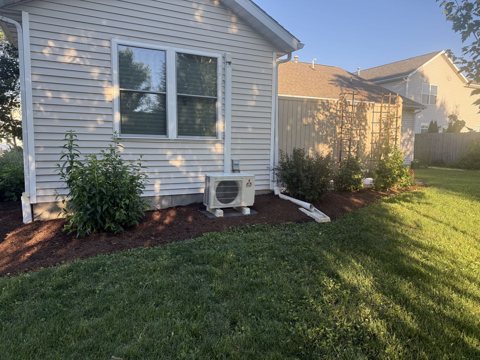 Mulch bed installation around a house corner in Bloomington, IN