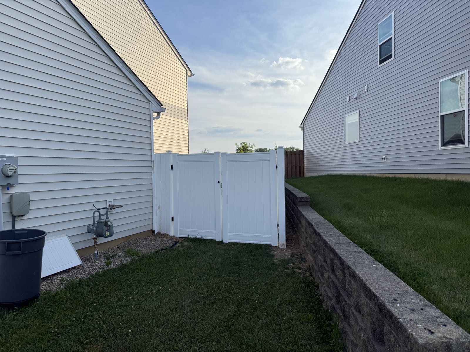 White vinyl privacy fence with double gate in a side yard in Bloomington, IN