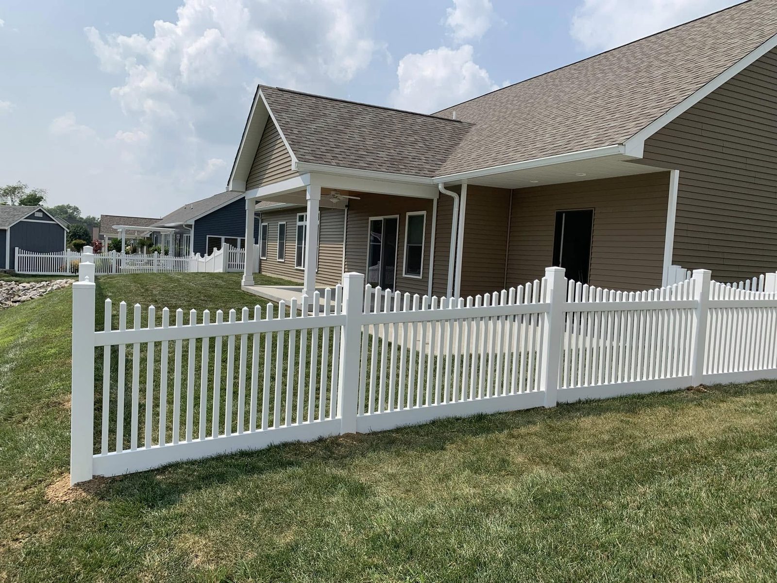 White vinyl picket fence in the front yard of a ranch home in Bloomington, IN
