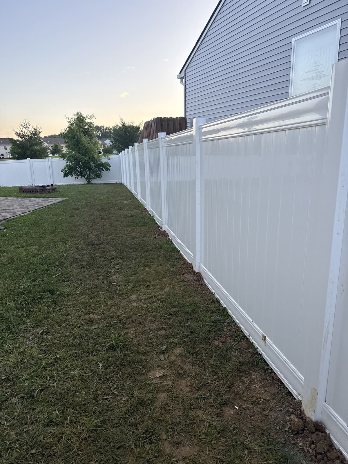 White vinyl privacy fence installed along the side of a home in Bloomington, IN