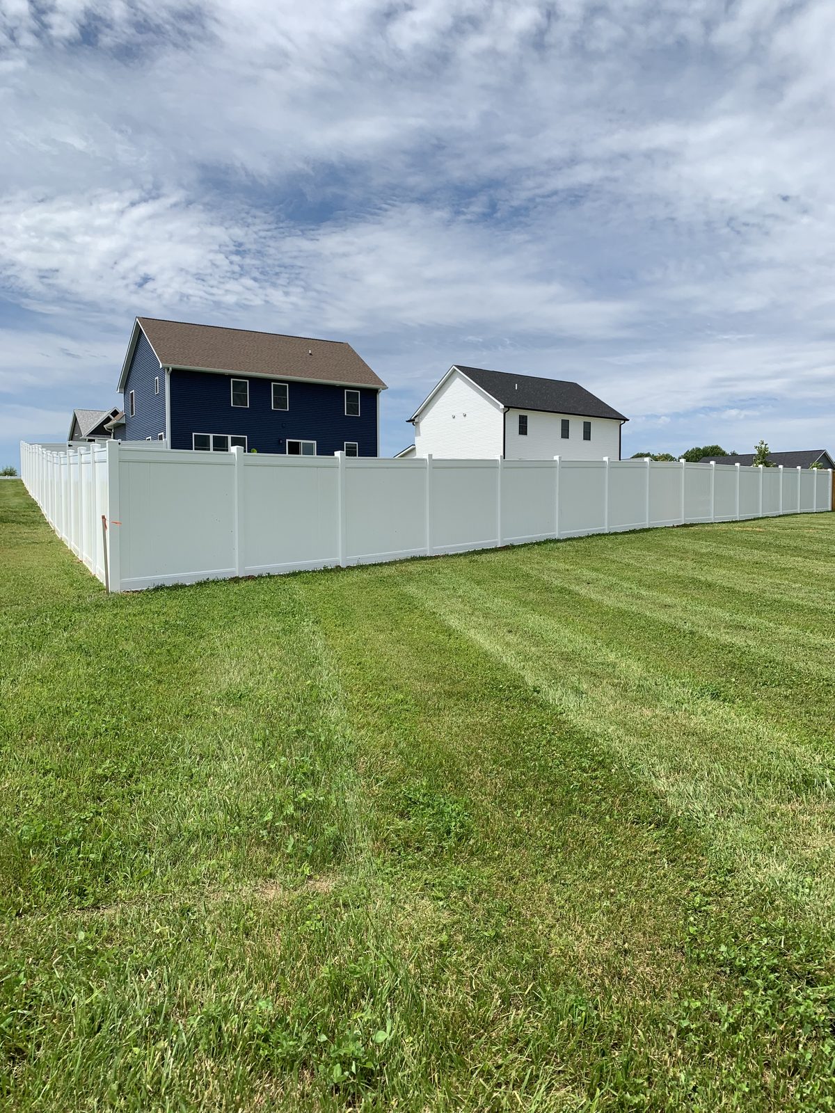 White vinyl privacy fence around a large yard in Bloomington, IN