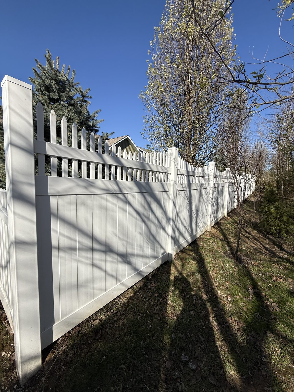 White vinyl privacy fence with a scalloped picket top in Bloomington, IN