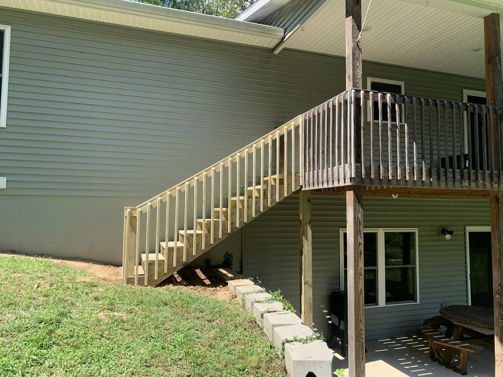Elevated wood deck with a staircase on a hillside home in Bloomington, IN