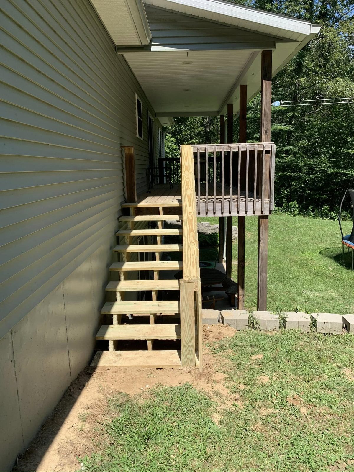 Wood deck and stairs installation on the side of a home in Bloomington, IN