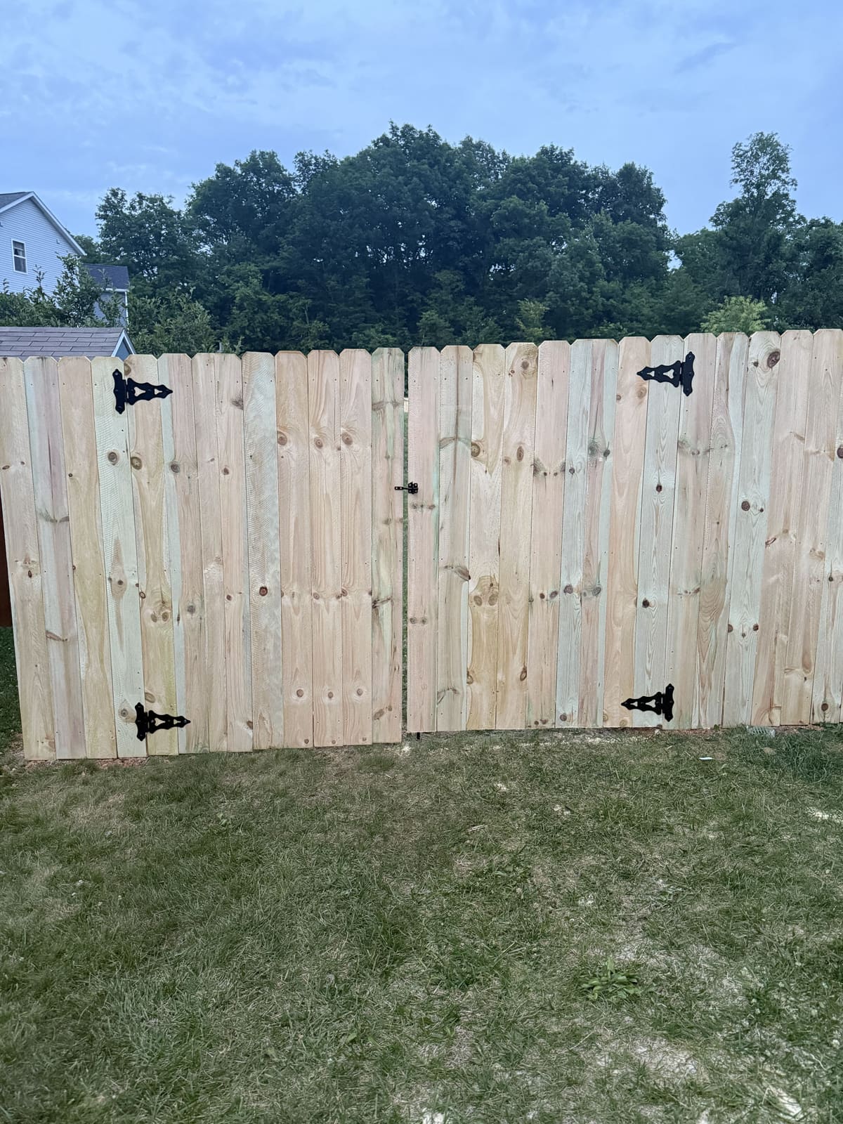 Wood fence double gate with black hinges in Bloomington, IN
